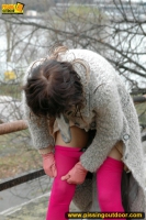 MILF brunette pissing on concrete lookout