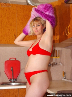 Mature blonde plays with her shaved pussy in the kitchen - N